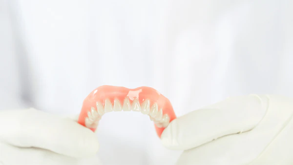 dentist holding a denture
